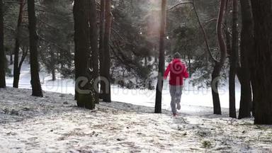 在寒冷的<strong>冬季</strong>森林里慢跑的女跑步者穿着温<strong>暖</strong>的运动服装和手套。
